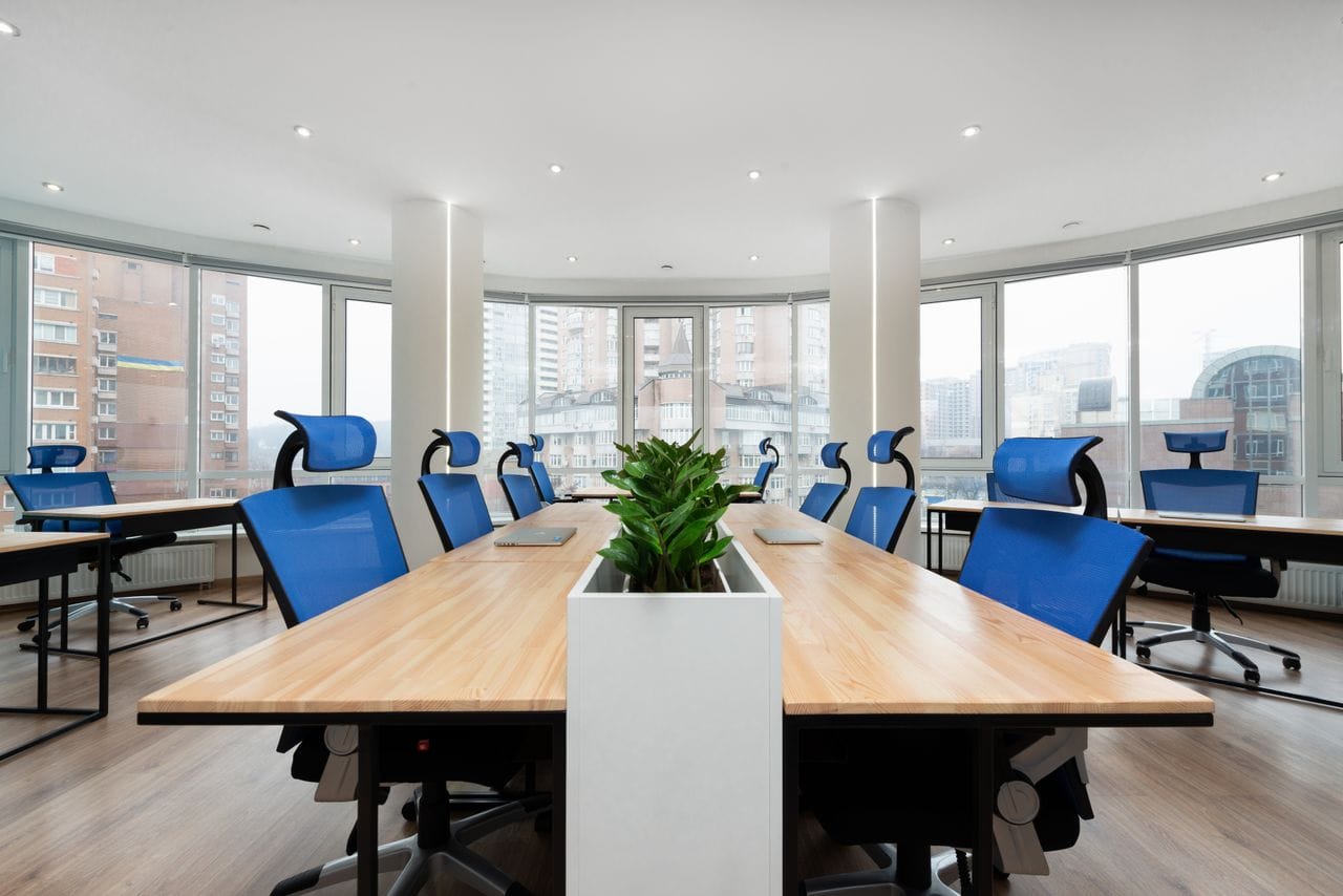 Spacious conference room with blue office chairs and natural light.